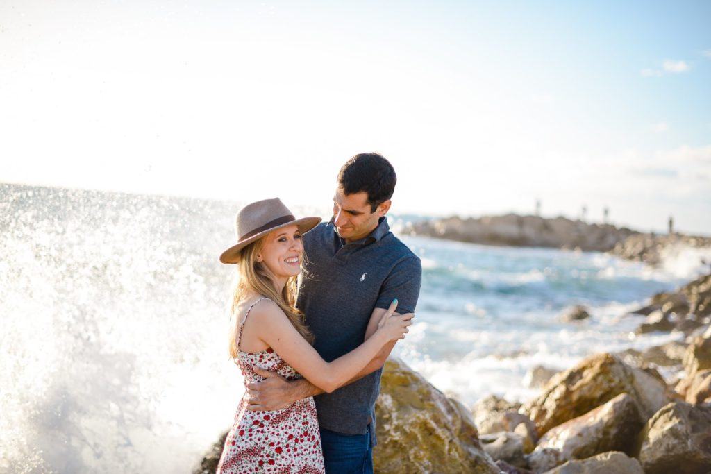 embracing man and woman on rocky beach for couples photoshoot