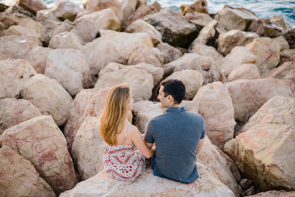 couples photoshoot with man and woman sitting among rocks