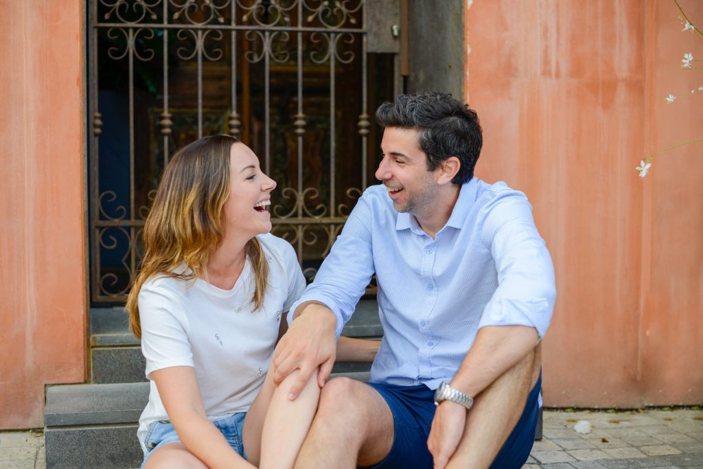 laughing seated couple in doorway for anniversary photoshoot