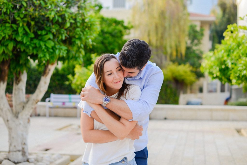 man hugging woman from behind in Neve Tzedek anniversary photoshoot