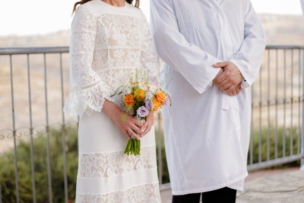 close up photo of bride with bouquet and groom