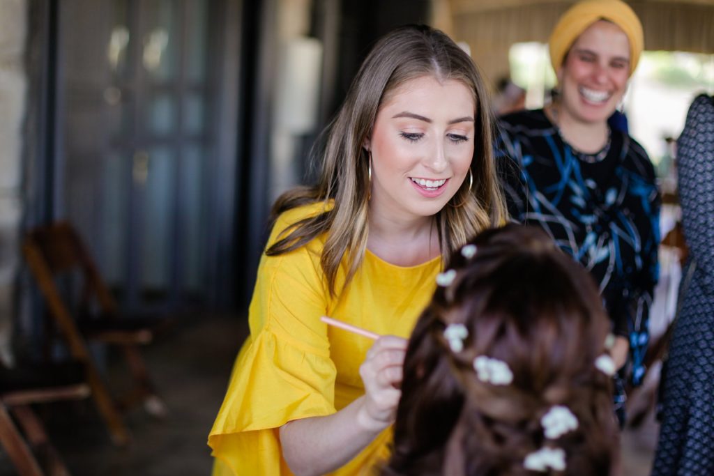 makeup artist applying makeup on bride 