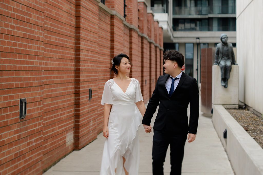 smiling bride and groom holding hands at a wedding photography session