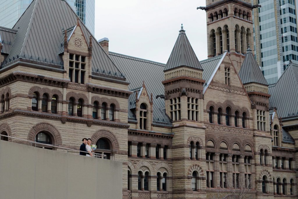 couple posing in front of toronto's city hall for their city hall wedding