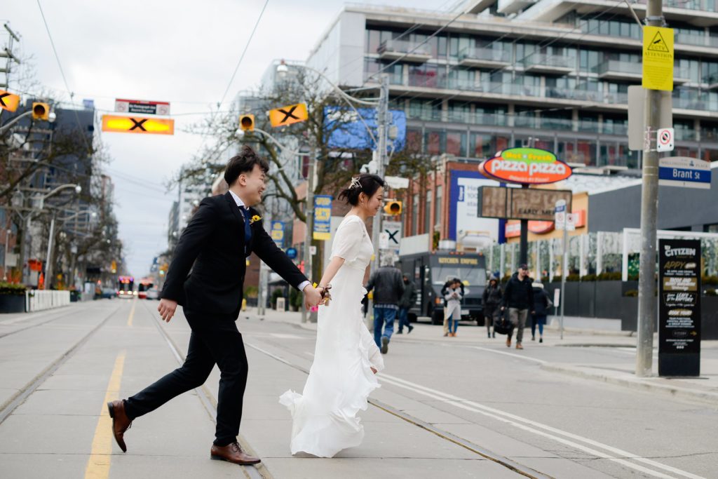 bride and groom crossing the street holding hands