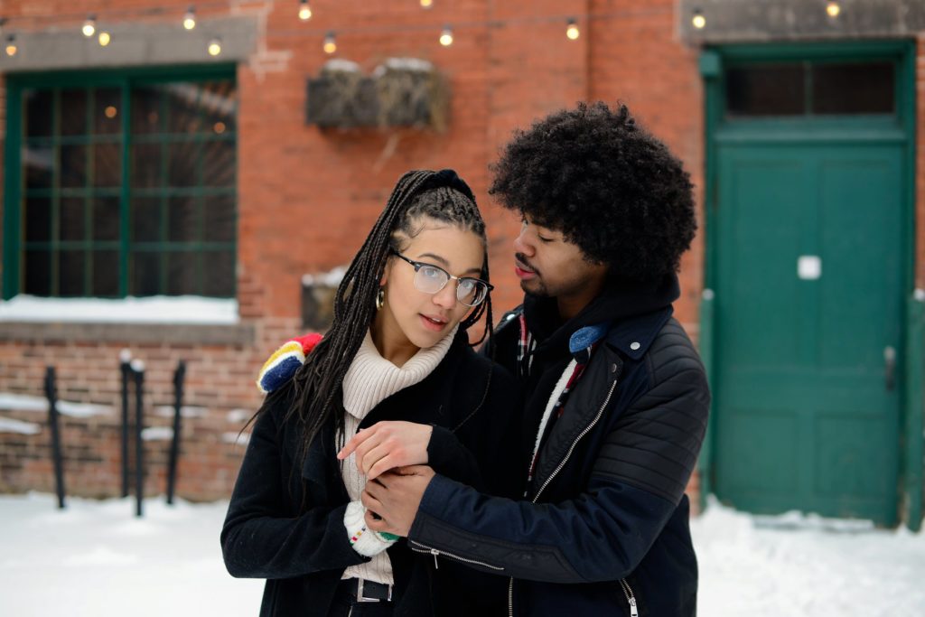 couple touching and posing outside for engagement photoshoot