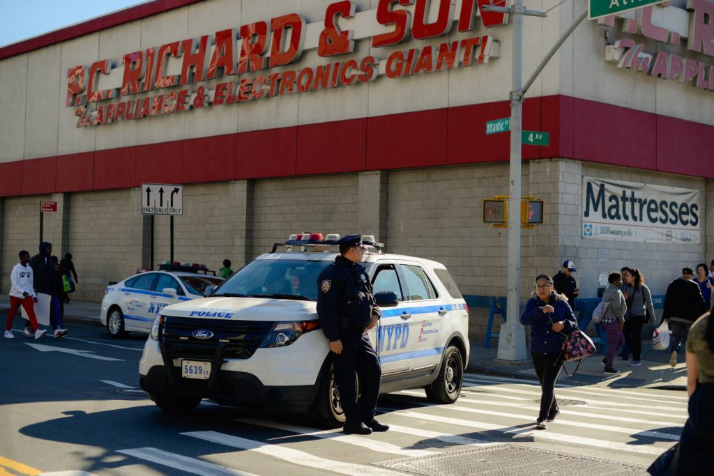 Brooklyn police office leaning against his car - Lauren Newman Photography