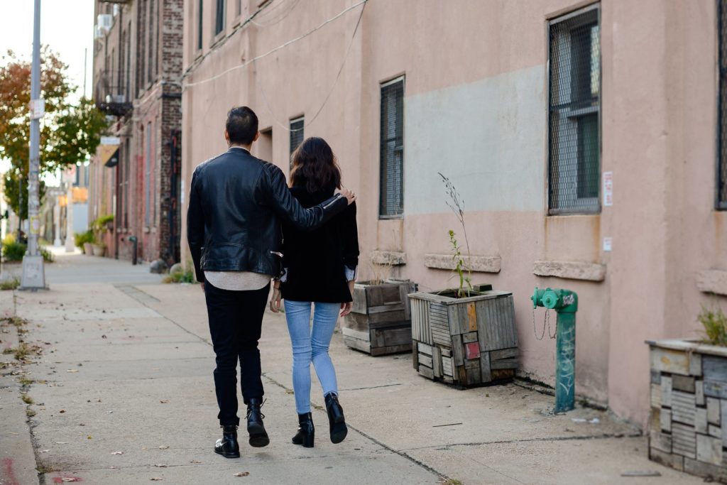 couple walking from behind with man's arm around woman's shoulder shot for engagement photoshoot