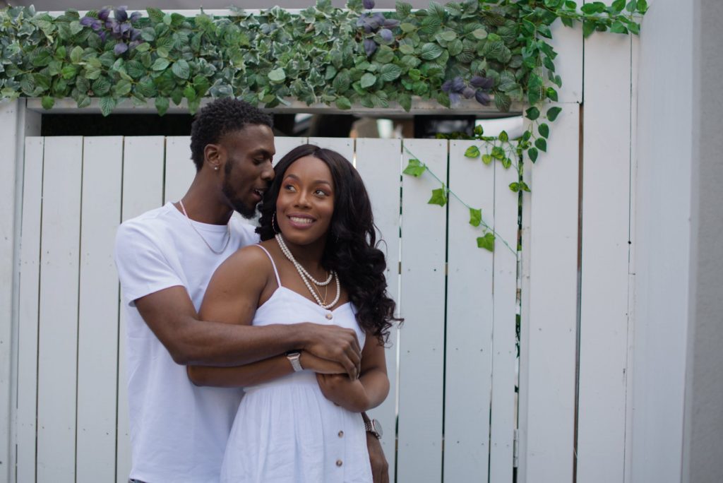 couple embracing with white wooden background