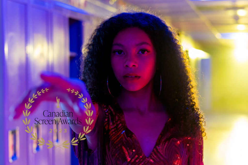 Simone Miller reaches out her hand in a red sequin dress as the looks to camera for poster of the Canadian Screen Awards