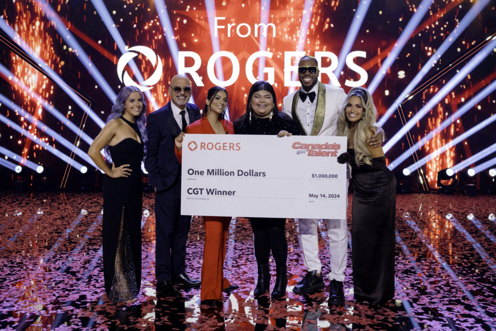 Singer Rebecca Strong hold Canadas Got Talent winners check from Rogers on stage with judges Howie Mandel, Lindsay Ell, Trish Stratus, Lilly Singh, Kardinal Offishall